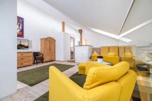 Una sala de estar con sillas amarillas y una mesa. en Landhaus Schösser-Brandler, en Mayrhofen