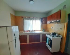 Una cocina con un refrigerador blanco y una estufa. en Casa Centrica 2 habitaciones con Cochera SL Cap, en San Luis