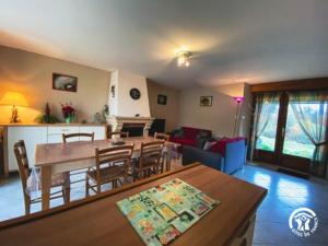 a dining room and living room with a table and chairs at le Chouette in Saint-Cyprien-sur-Dourdou