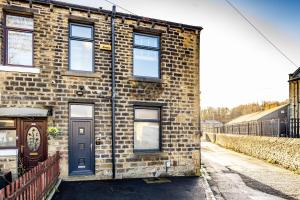 een bakstenen gebouw met een blauwe deur op een straat bij Raynbow Apartments x in Huddersfield