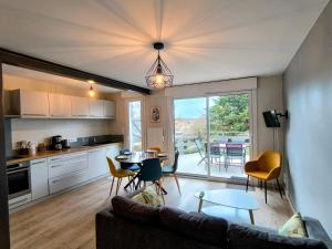 a living room with a couch and a table at La Mésange - Cosy - 10mn du Parc in Mauléon