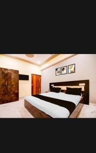 een slaapkamer met een groot bed met zwart-witte lakens bij Hotel PANCHSHIL in Patna +11 foto's