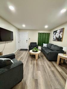 a living room with couches and a flat screen tv at Cozy Home Near Dearborn in Detroit
