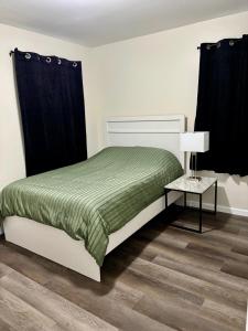 a bedroom with a bed and a table with a lamp at Cozy Home Near Dearborn in Detroit