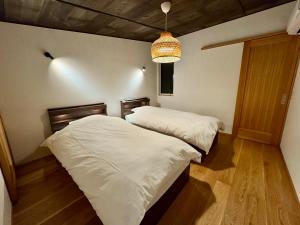 une chambre avec deux lits et un lustre dans l'établissement Villa Monica Premium, à Nagoya
