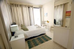 a small bedroom with a bed and a window at Pissouri Village Studios in Pissouri