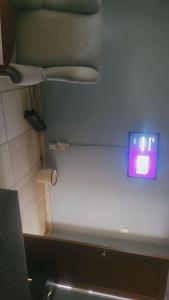 a bathroom with a white wall with a clock on it at Rainbow Guest House in Maraisburg