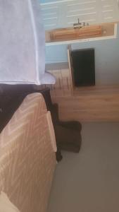 a bedroom with a bed and a flat screen tv at Rainbow Guest House in Maraisburg