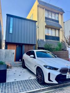 une voiture blanche garée devant une maison dans l'établissement Villa Monica Premium, à Nagoya