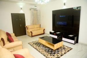 uma sala de estar com uma grande TV de tela plana em Luxurious Duplex in Oredo, Benin City - Perfect for Families and Groups em Ekae