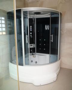 um chuveiro num quarto com uma parede de vidro em Luxurious Duplex in Oredo, Benin City - Perfect for Families and Groups em Ekae mais 55 fotografias