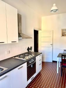 Una cocina con gabinetes blancos y un horno de estufa. en Il Mughetto, en Rapallo