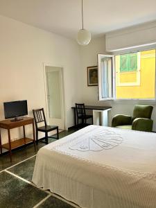 Un dormitorio con una cama, un sofá y un televisor. en Il Mughetto, en Rapallo