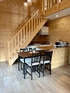 een eetkamer met een tafel en stoelen en een trap bij Chalet Iris, spa privatif, 4p in Rochesson
