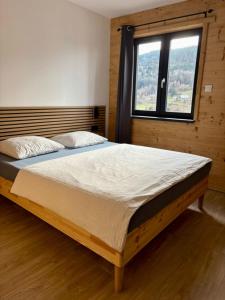 een groot bed in een kamer met een raam bij Chalet Iris, spa privatif, 4p in Rochesson