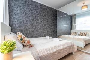 a bedroom with two beds and a mirrored wall at WrocApartments StarCenter - Parking Free in Wrocław