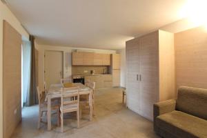 eine Küche und ein Esszimmer mit einem Tisch und einer Couch in der Unterkunft Appartamento Alpen Molveno in Molveno