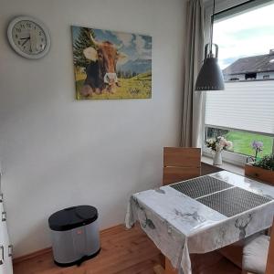 ein Tisch in einem Raum mit einem Bild einer Kuh in der Unterkunft Ferienwohnung Bergfrieden in Fischen im Allgäu