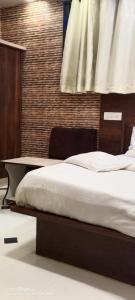 a bed in a room with a table and a bed sidx sidx at hotel VIJAY in Mount Ābu