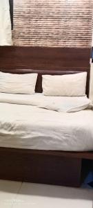 two beds with white sheets and pillows at hotel VIJAY in Mount Ābu
