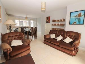 a living room with two leather couches and a dining room at 1 Windermere in Kinvara