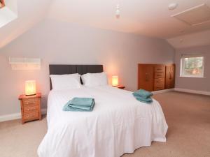 a bedroom with a large white bed with towels on it at 1 Windermere in Kinvara