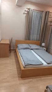 a bedroom with a bed with a wooden frame at Hermina apartmanház in Budapest