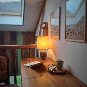 Coume a Case - Gîte 4 étoiles - Charme et nature Vallée d Ossau في Lys: طاولة عليها مصباح وكوب