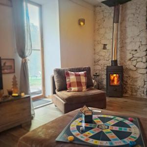 Coume a Case - Gîte 4 étoiles - Charme et nature Vallée d Ossau في Lys: غرفة معيشة مع أريكة وموقد خشبي