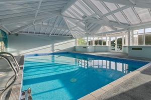 a swimming pool in a house with a ceiling at Manor House Apartment - Indoor Heated Pool, Parking in Torquay