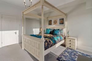 a bedroom with a white canopy bed with blue pillows at Manor House Apartment - Indoor Heated Pool, Parking in Torquay +32 photos