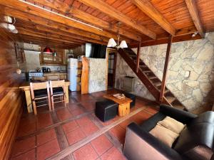 un soggiorno con un divano, un tavolo e una cucina di Cabañas Gusfraba a Villa Gesell