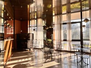 a room with chairs and tables in a building with windows at La Fenice Hotel in Reggello