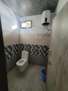 a small bathroom with a toilet and a window at DHARAMSHALA inn MUNSYARI in Munsyari