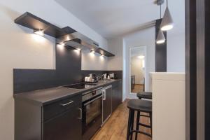 uma cozinha com armários pretos, um lavatório e um balcão em Design & Lifestyle Hotel Estilo em Aalen