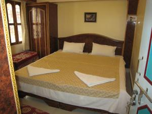a bedroom with a bed with two towels on it at Kedareswar B&B in Varanasi