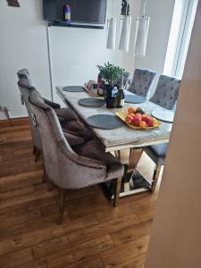una mesa de comedor con sillas y fruta. en Festohomes1 at rushden, en Rushden 4 fotos más