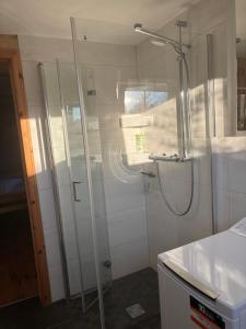 una doccia con una porta in vetro in un bagno di Behagliches Cottage am See a Fürstenberg/Havel Altre 14 foto