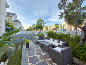 ein Garten mit einer Bank und Bäumen und einem Zaun in der Unterkunft Le Chattok Villa in Bình Tú