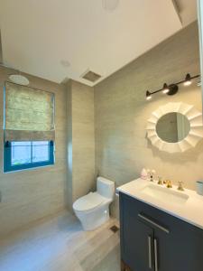 ein Badezimmer mit Toilette, Waschbecken und Spiegel in der Unterkunft Le Chattok Villa in Bình Tú