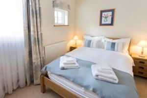 een slaapkamer met een bed met handdoeken erop bij The Stables at Boreham House in Herstmonceux