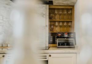 eine Küche mit weißen Schränken und einer Mikrowelle in der Unterkunft Le Chattok Villa in Bình Tú + 13 Fotos