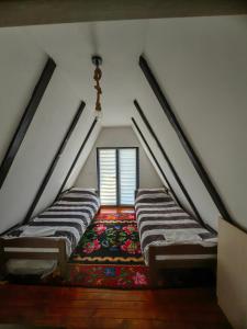 a attic room with two beds and a rug at Planinska kuca TM in Jahorina