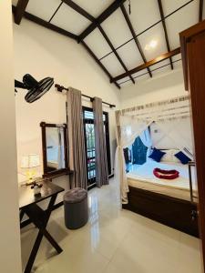 een slaapkamer met een groot bed met een tafel en een spiegel bij Windy Villa in Mirissa