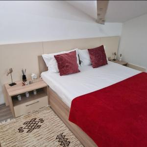um quarto com uma cama grande com travesseiros vermelhos em Square Apartment em Paraćin