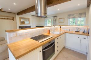 a large kitchen with white cabinets and a sink at The Stables at Boreham House in Herstmonceux
