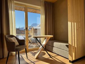 a room with a table and a chair and a window at Hotel Damelis - Adults Only in Livigno