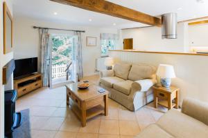 a living room with a couch and a tv at The Stables at Boreham House in Herstmonceux