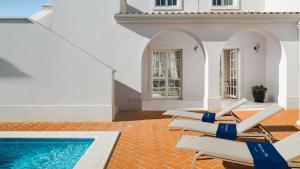a group of lounge chairs next to a swimming pool at Luxury villa Adele with pool in Porec in Vabriga