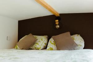 a bedroom with a white bed with two pillows at Tiny house Malý gurmán in Rohozná